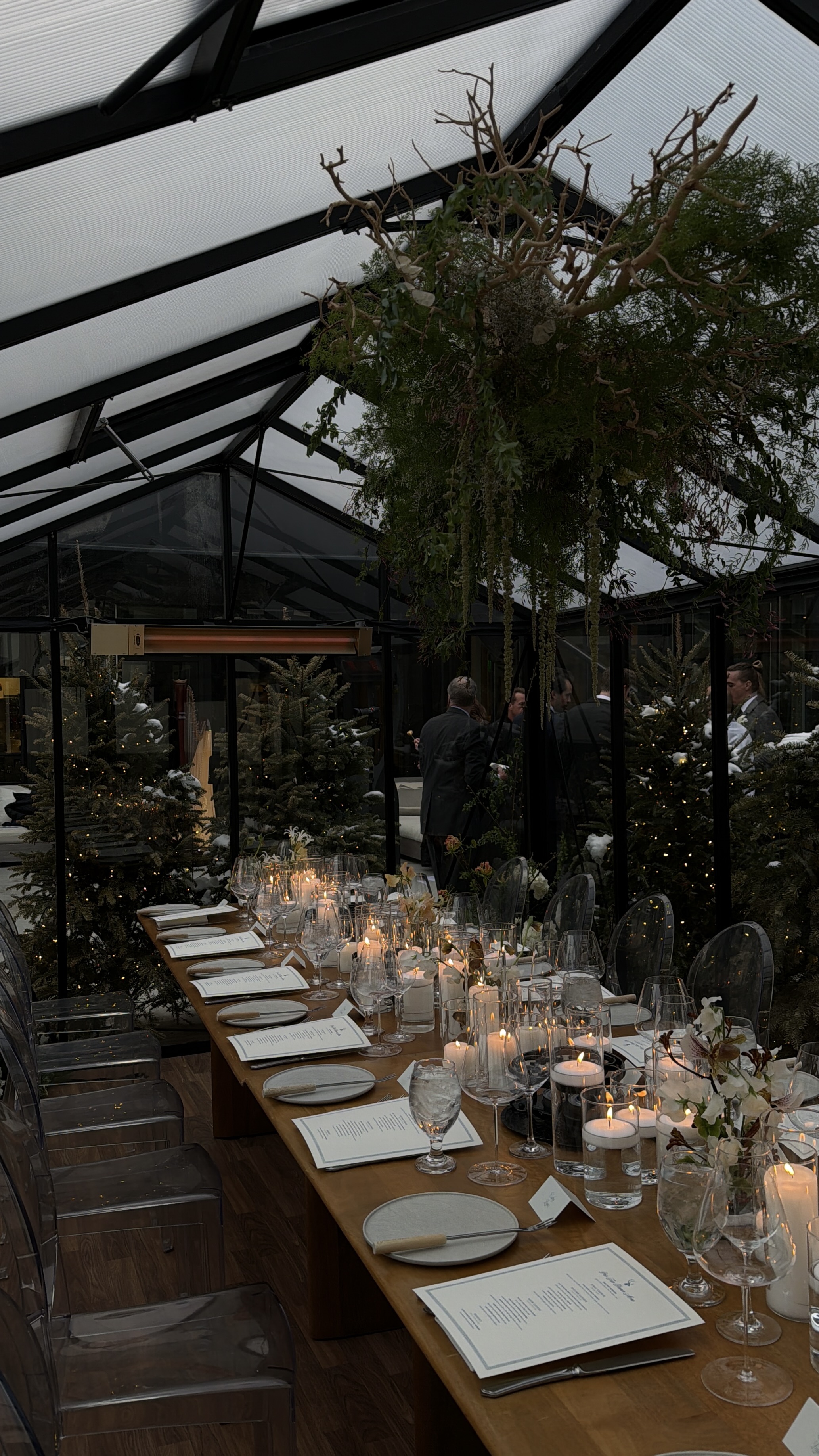 Greenhouse dinner tablescape with candles and greenery